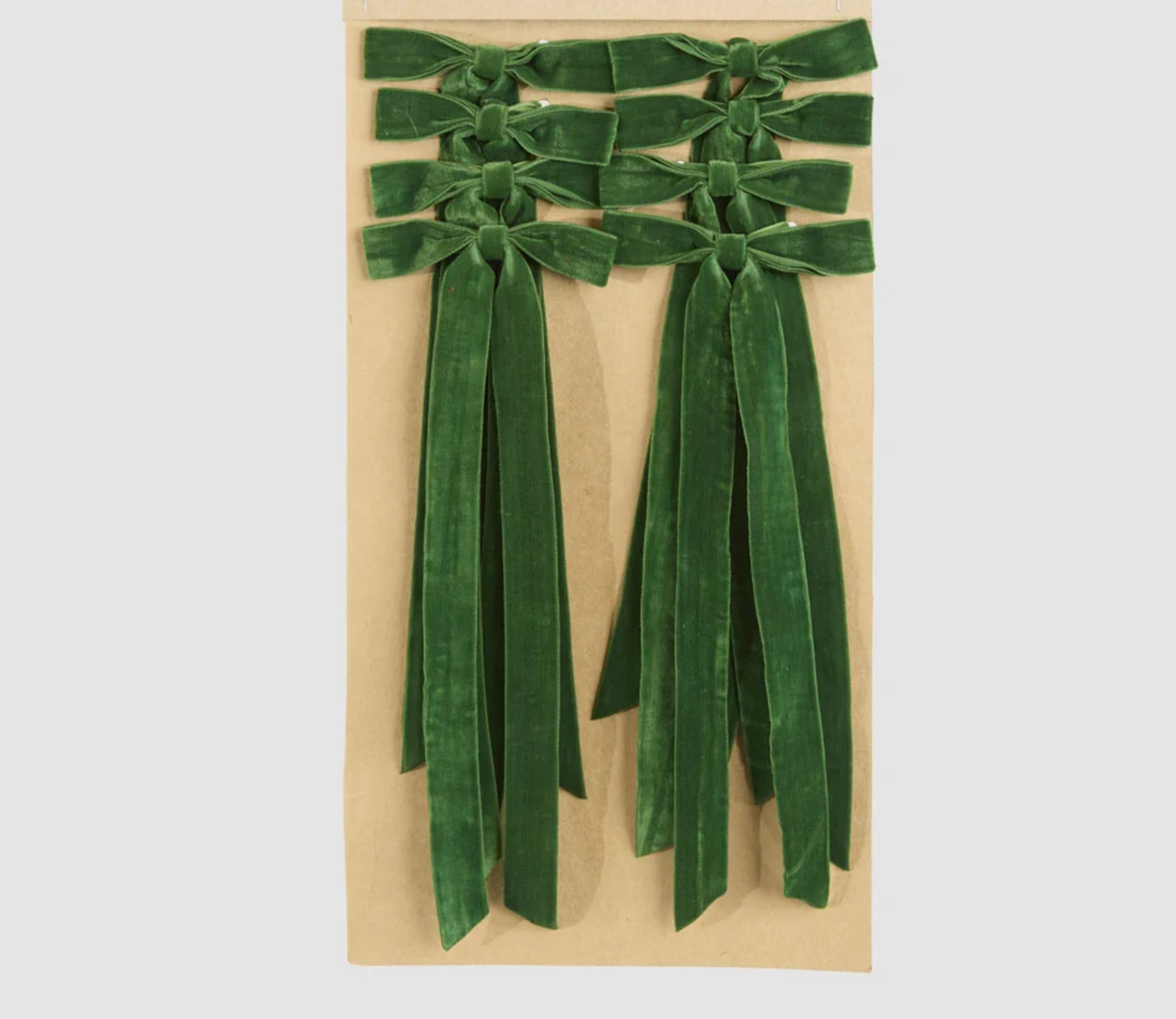 Eight green velvet tie-on bows arranged on a backing card with long ribbon tails
