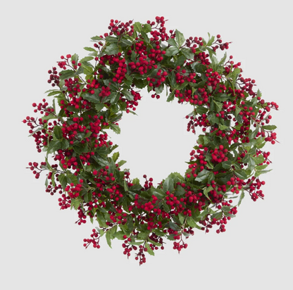 Front view of an artificial holly wreath with green pointed leaves and clusters of red berries