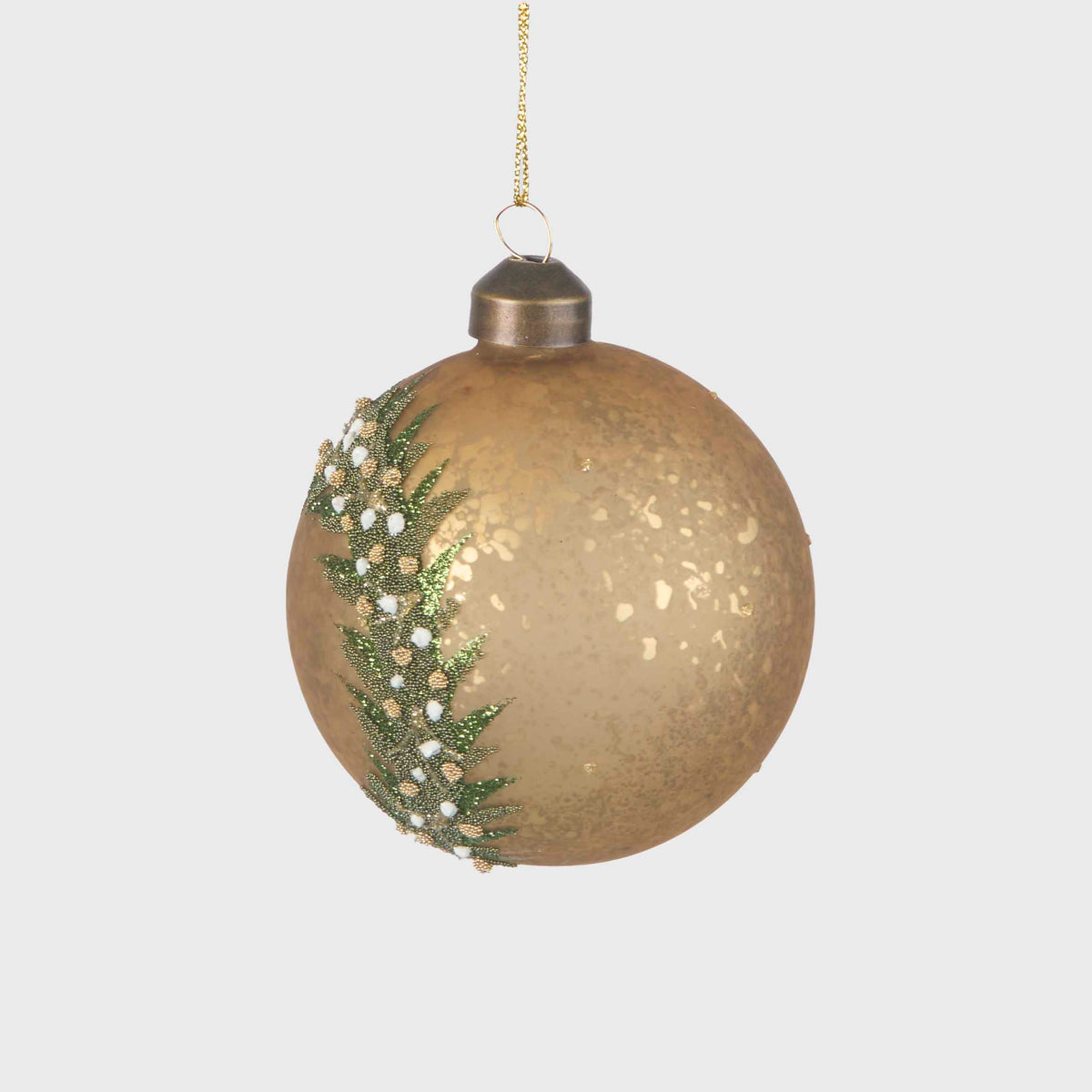 Side view of the gold glass bauble showing its mottled finish and green wreath detail
