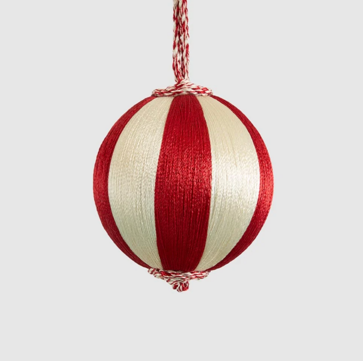 Small red and ivory striped bauble hanging from a twisted cord