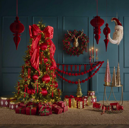 Close-up of the red satin bow showing its wrapped centre and folded loop on Christmas tree branches
