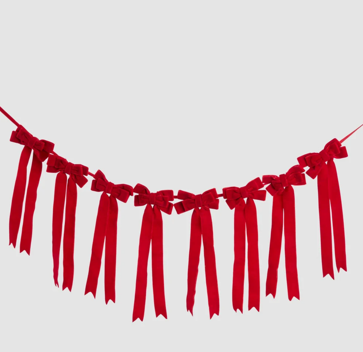 Red velvet bow garland hanging in a curve, with repeated bows and long notched ribbon tails