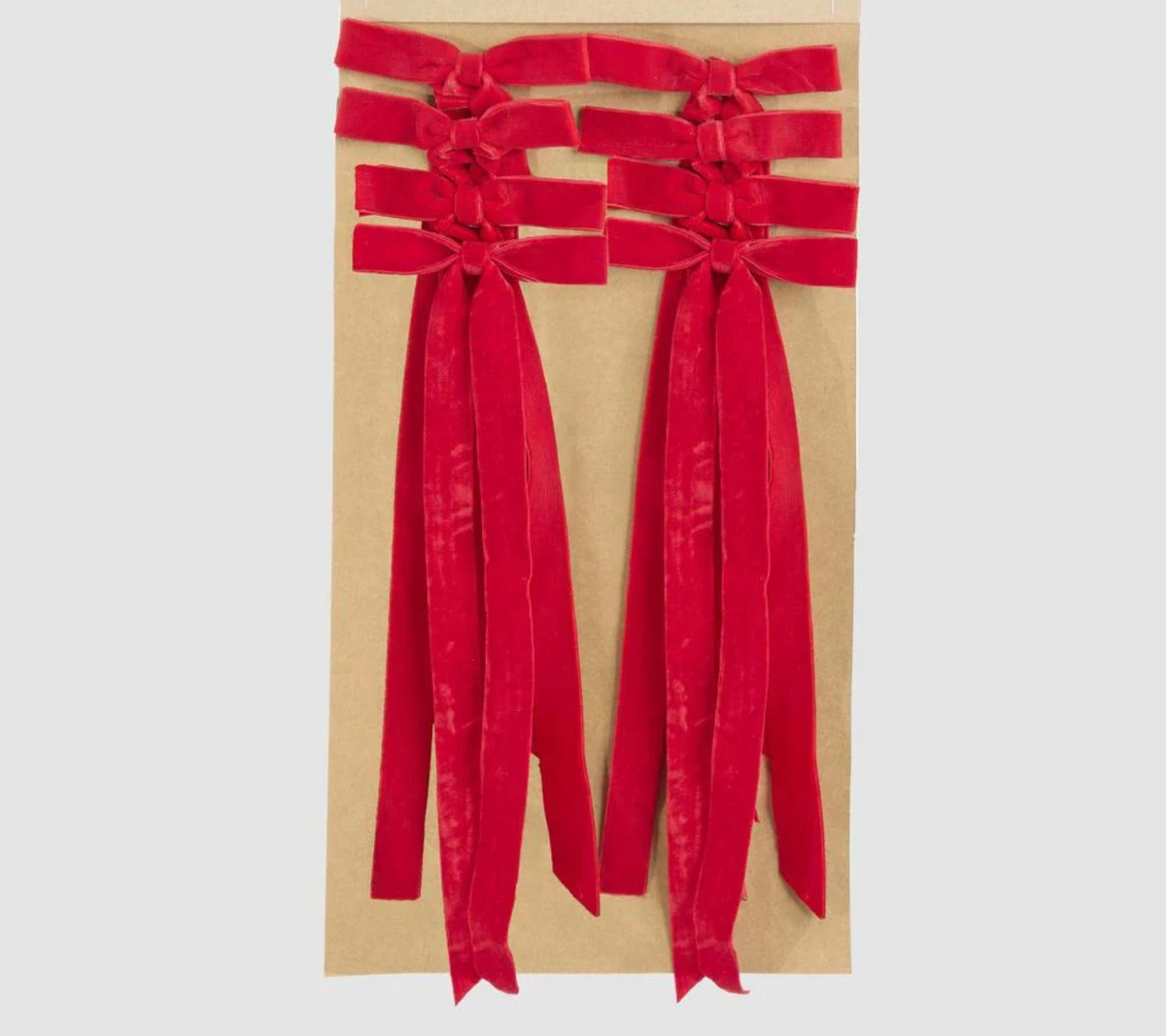 Close-up of a red velvet tie-on bow with long ribbon tails and a narrow tying ribbon