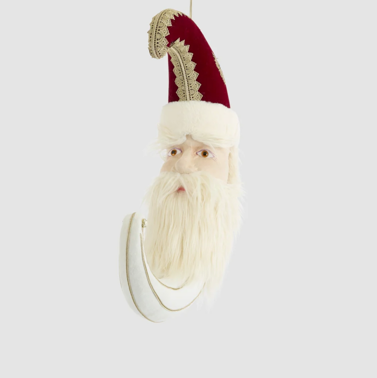 Angled view of the Santa moon decoration showing its curved cream crescent and red hat
