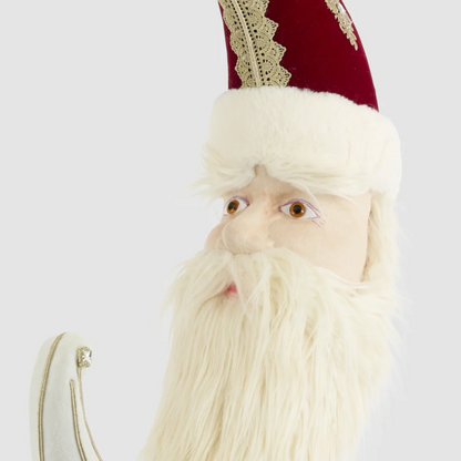 Close-up of Santa's face, cream beard and red hat with cream and gold-coloured decorative edging