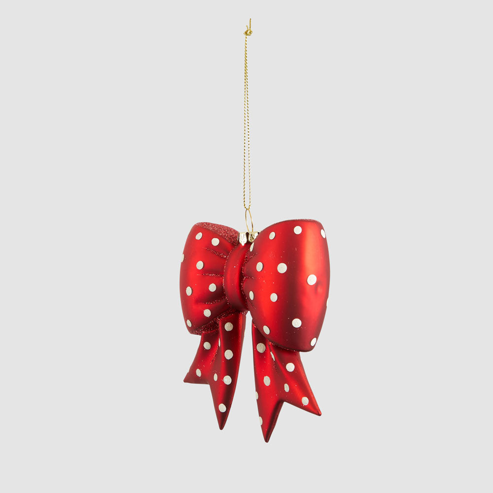 Angled view of the red and white spotted glass bow with its full gold-coloured hanging cord