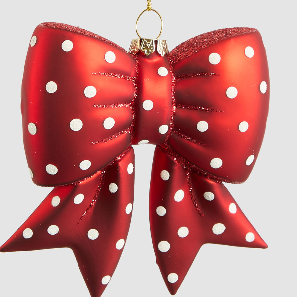 Close-up of white spots and red glitter details on the glass bow hanging decoration