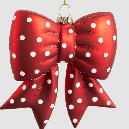 Close-up of white spots and red glitter details on the glass bow hanging decoration