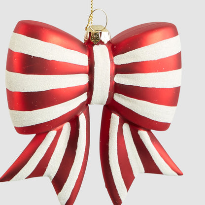 Close-up of the red and white striped glass bow showing textured white stripes and pointed ribbon tails