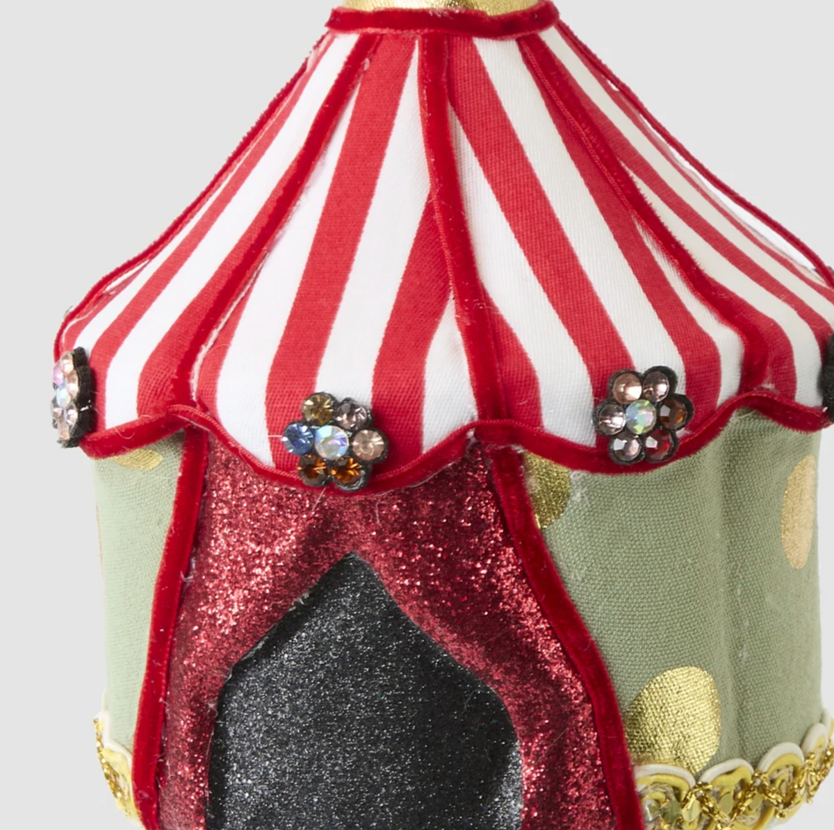 Close-up of the tent decoration showing striped roof, flower-shaped jewel details and gold-coloured trim